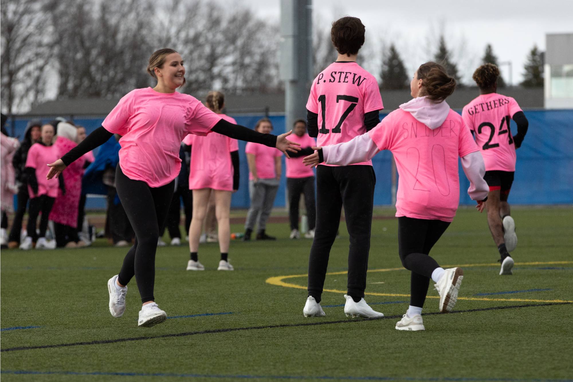 2 students high-fiving while playing soccer